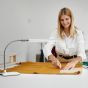 Daylight Company UnoPro Table Lamp - lifestyle shot, using the lamp to do sewing