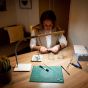 Daylight Company UnoPro Table Lamp - lifestyle shot, using the lamp to do crafting