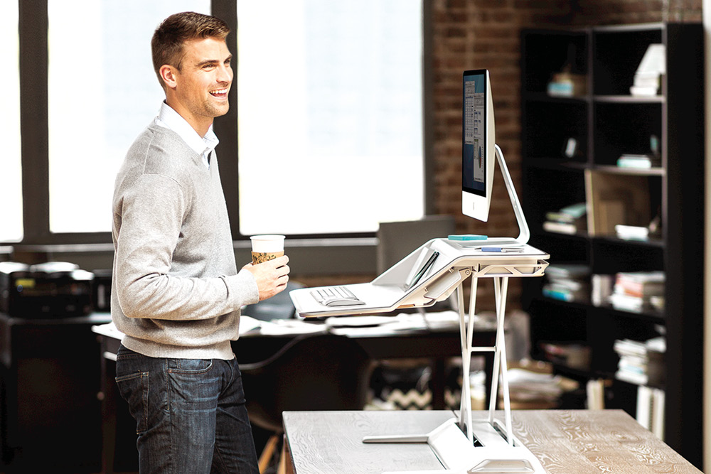 Man happy at work using a standing desk